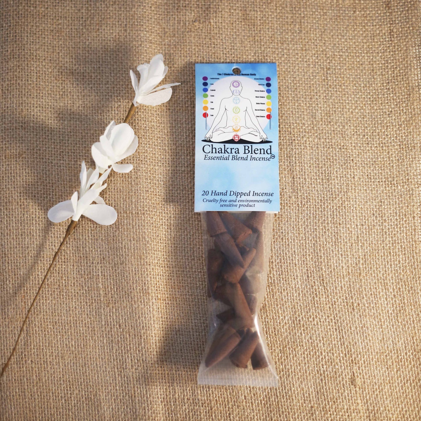 Chakra Blend essential blend incense package with decorative white flowers on a textured brown background