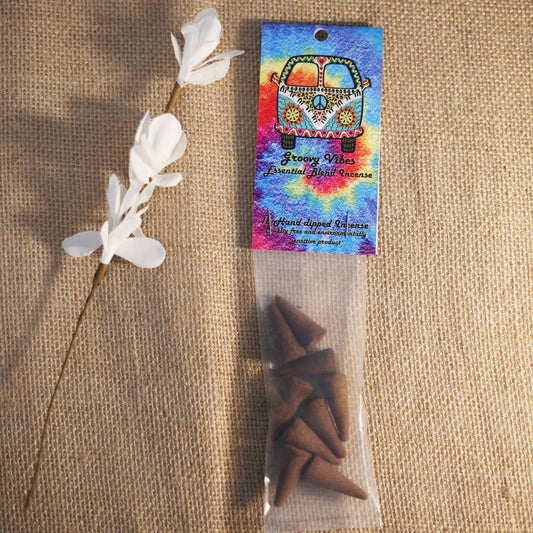 Packaged incense cones with a colorful label on a textured surface